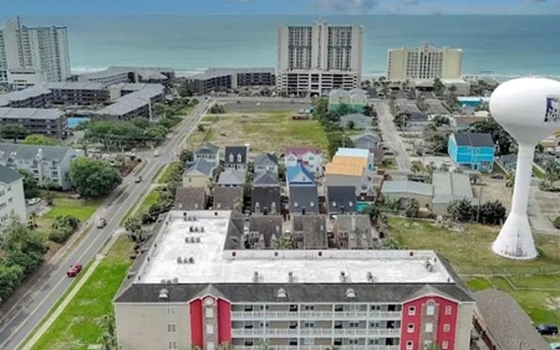 Aerial view of beachfront residential buildings and hotels along Gulf coast with ocean and sky