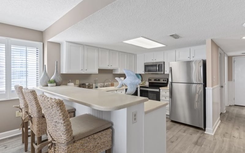 Modern kitchen with white cabinetry, stainless steel appliances, and island with seating